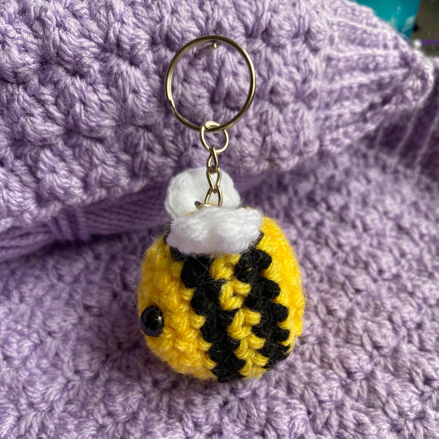 Crochet cute bee keyring with a purple yarn background